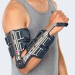 Elbow orthosis with simple dressing, adjustment and maintenance. The frame of the orthosis is made of duralumin, the elbow and forearm sleeves are made of breathable padded material. Numbered circular straps make closing easier. Individually adjustable shoulder strap with padding around the neck. The forearm part is extended by an adjustable wrist module relieving the wrist. The weight of this orthosis is only 423 grams.