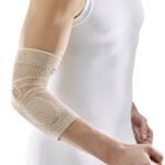 Elbow bandage with relief and stabilization of the elbow joint with anatomically shaped knit bandage. The bandage helps to rapidly resorb edema and hematomas, relieve pain and restore joint function. The end of the bandage with a reduced compression effect guarantees a comfortable fit without symptoms of blood accumulation and circulatory disorders. The new type of knitwear guarantees high wearing comfort and is particularly comfortable in the elbow area.